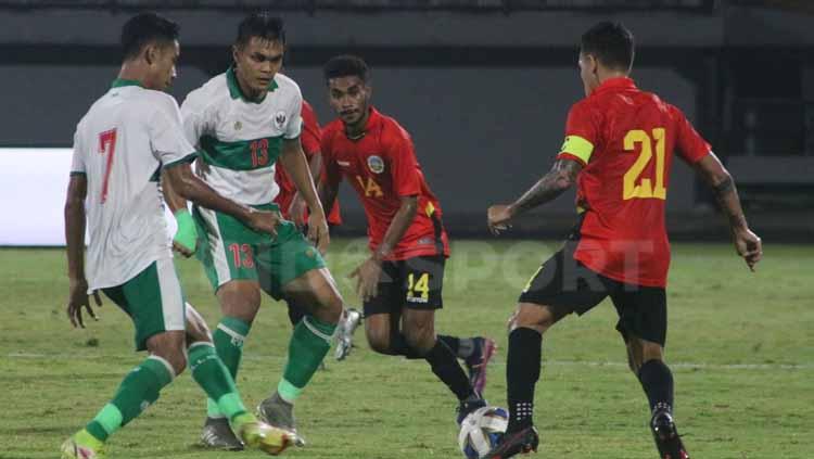 Rachmat Irianto (13) kawal ketat pergerakan pemain Timor Leste di Stadion Kapten I Wayan Dipta, Gianyar, Minggu (30/1/22). Foto : Nofik Lukman Hakim - INDOSPORT