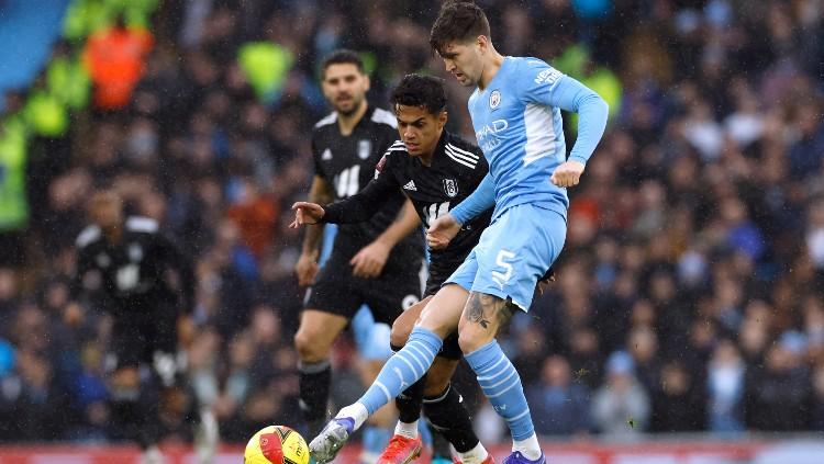 John Stones berduel dengan Fabio Carvalho di laga Piala FA Man City vs Fulham (05/02/22). (Foto: Reuters/Jason Cairnduff)