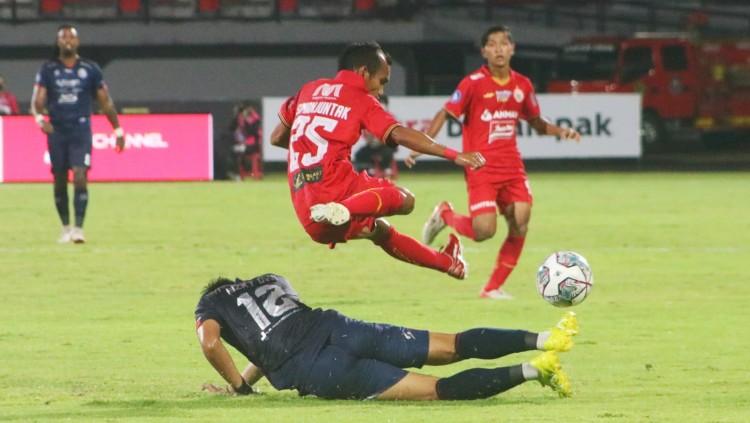 Winger Persija Jakarta, Riko Simanjuntak saat menghindari tackling bek Arema FC, Rizki Dwi Febrianto dalam lanjutan BRI Liga 1 2021/2022 di Stadion Kapten I Wayan Dipta, Gianyar, Sabtu (5/2/22).