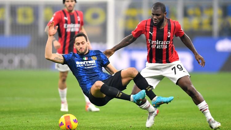 Hakan Calhanoglu berduel dengan Franck Kessie di laga Inter Milan vs AC Milan (06/02/22). (Foto: REUTERS/Daniele Mascolo) - INDOSPORT