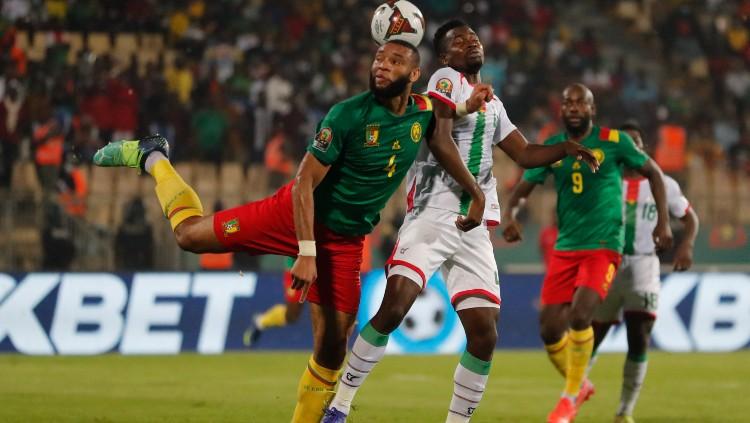 Harould Moukoudi (kiri) memenangi duel udara di laga Burkina Faso vs Kamerun (06/02/22).(Foto: REUTERS/Mohamed Abd El Ghany)