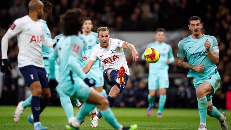 Harry Kane melepaskan tembakan ke gawang Brighton yang berbuah gol untuk Tottenham Hotspur (06/02/22). (Foto: Reuters/John Sibley)