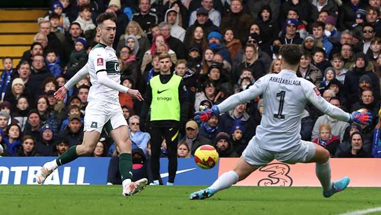 Kepa Arrizabalaga mengamankan serangan sekaligus tendangan dari pemain Plymouth Argyle Ryan Hardie pada laga di Stamford Bridge, Minggu (06/02/22). FOTO: Reuters/Paul Childs - INDOSPORT
