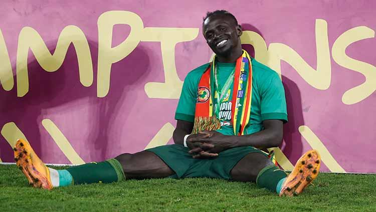 Sadio Mane merayakan kemenangannya dengan duduk santai sambil tersenyum setelah Timnas Senegal juara Piala Afrika di stadion Stadion Olembe, Yaounde. Senin (07/02/22). FOTO: REUTERS/Mohamed Abd El Ghany - INDOSPORT