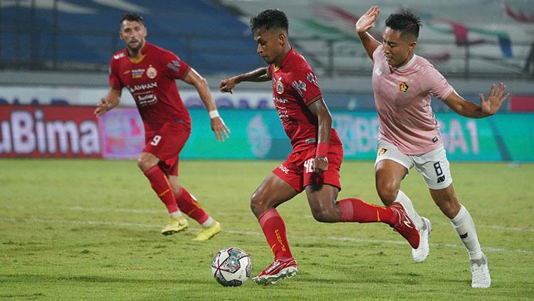 Pemain Persija Jakarta sedang membawa dan dikawal oleh pemain Persik Kediri di Liga 1.