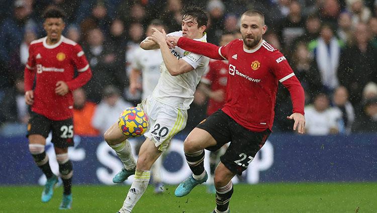 Luke Shaw sedang berduel merebut bola dengan pemain Leeds United di Liga Inggris.