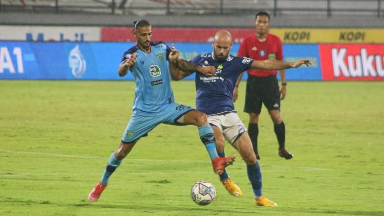 Duel gelandang Persela Lamongan, Selwan Aljaberi dengan gelandang Persib Bandung, Mohammed Rashid dalam lanjutan Liga 1 2021/2022 di Stadion Kapten I Wayan, Dipta, Gianyar, Jumat (25/2/22) malam. (Foto : Nofik Lukman Hakim/INDOSPORT) - INDOSPORT
