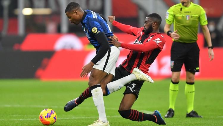 Fikayo Tomori (kanan) melancarkan tekel ke arah Denzel Dumfries di laga AC Milan vs Inter Milan (02/03/22). (Foto: REUTERS/Daniele Mascolo) - INDOSPORT