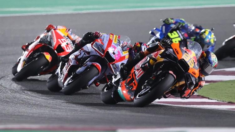 Brad Binder (depan), Enea Bastianini (tengah) dan Marc Marquez (belakang) beraksi di MotoGP Qatar (06/03/22). (Foto: REUTERS/Ibraheem Al Omari)