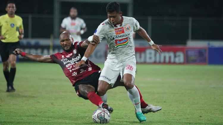 Bek Bali United, Leonard Tupamahu (tengah) melancarkan tekel ke arah striker Persija Taufik Hidayat pada pekan ke-29 Liga 1 di Stadion Ngurah Rai, Minggu (06/03/33).