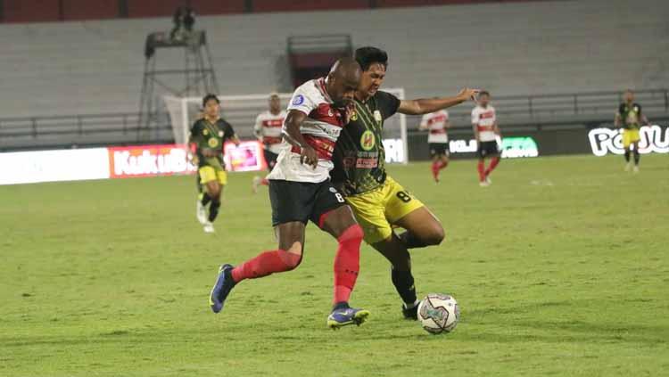 Greg Nwokolo pertahankan bola dari serangan pemain Barito Putera. FOTO: MO Madura Utd