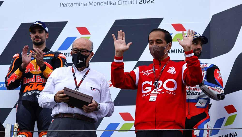 Presiden Joko Widodo dan CEO Dorna Carmelo Ezpeleta naik ke podium usai balapan di Sirkuit Internasional, Lombok, Minggu (20/03/22). Foto: Reuters/Willy Kurniawan - INDOSPORT