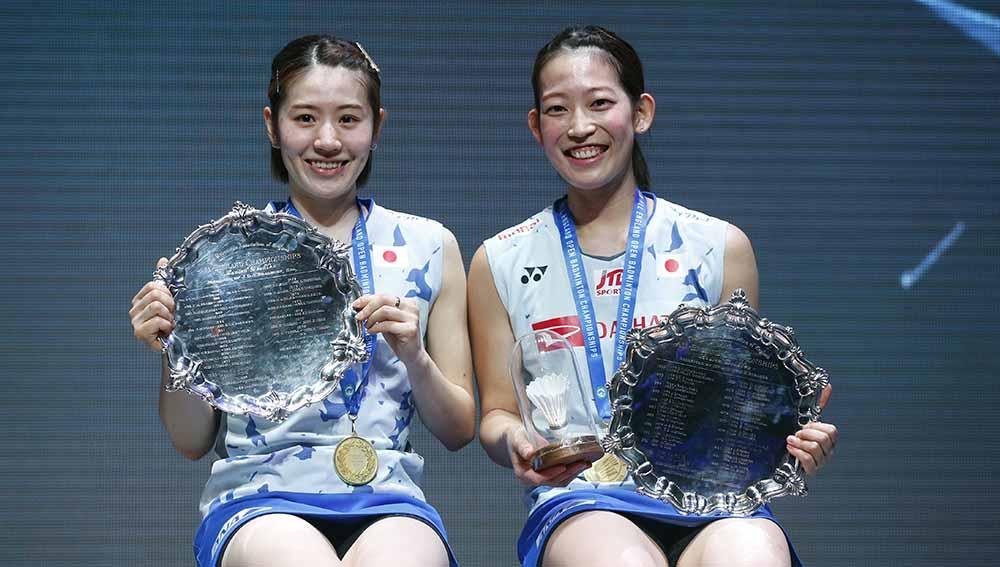 Pasangan ganda putri asal Jepang, Chiharu Shida dan Nami Matsuyama merayakan dengan trofi usai memenangkan final ganda putri di All England Open 2022. Foto: Reuters/Ed Sykes - INDOSPORT
