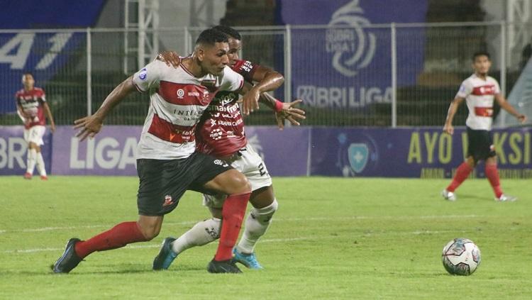 Perebutan bola gelandang Bali United, Eber Bessa dengan bek Madura United, Jaimerson Xavier. Foto : Nofik Lukman Hakim/INDOSPORT