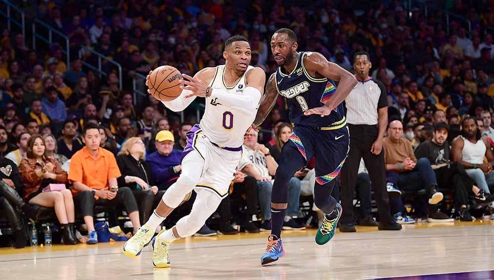 Pebasket Los Angeles, Lakers Russell Westbrook bergerak berusaha melewati pebasket Denver Nuggets. Davon Reed di laga MBA, Senin (04/04/22). Foto: Reuters/Gary A. Vasquez - INDOSPORT