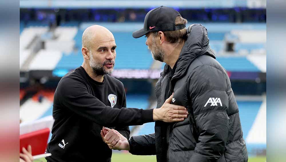 Pelatih Manchester City Pep Guardiola dan pelatih Liverpool Juergen Klopp berjabat tangan di Liga Inggris, Minggu (10/04/22). Foto: Reuters/Carl Recine