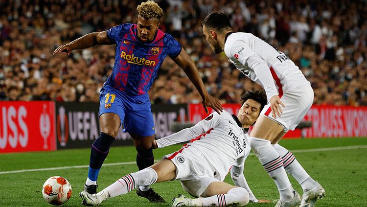 Pemain Barcelona, Adam Traore dikawal pemain Eintracht Frankfurt di pinggir lapangan.