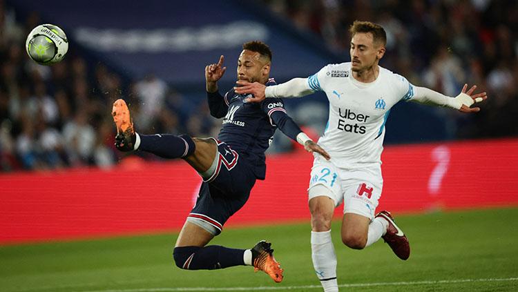 Pemain Paris Saint-Germain (PSG) berusaha menjangkau bola tapi coba diganggung pemain Marseille.