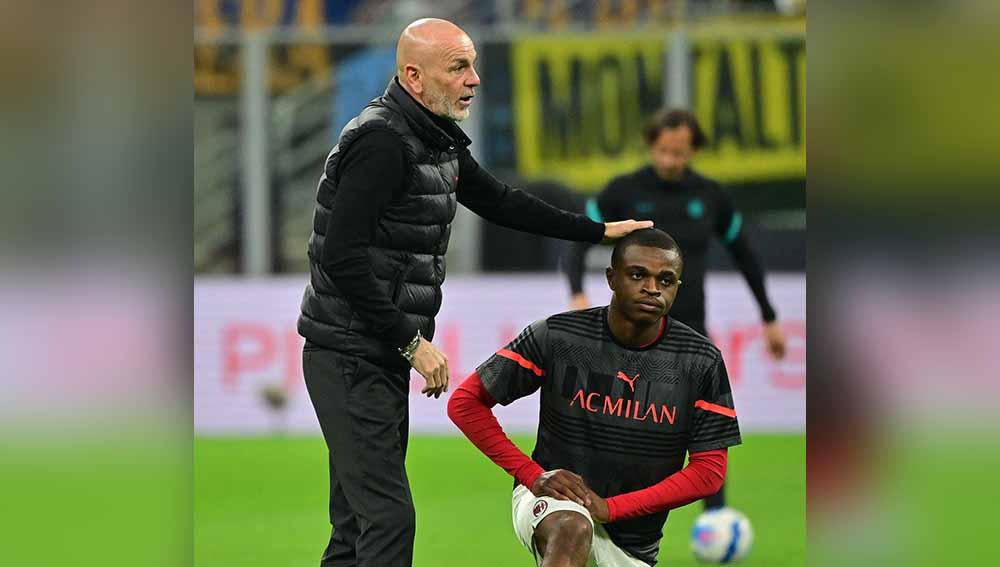 Pemain AC Milan Pierre Kalulu saat pemanasan sebelum pertandingan dengan pelatih Stefano Pioli. Foto: REUTERS/Alberto Lingria