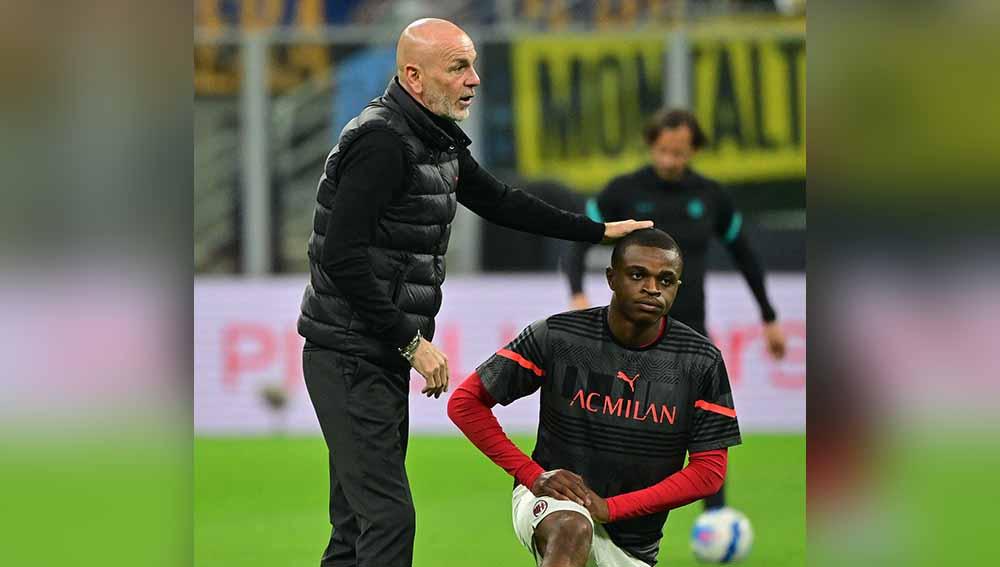 Indosport - Pemain AC Milan Pierre Kalulu saat pemanasan sebelum pertandingan dengan pelatih Stefano Pioli. Foto: REUTERS/Alberto Lingria