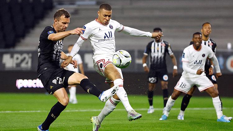 Pemain Paris Saint-Germain (PSG), Kylian Mbappe coba menendang bola.
