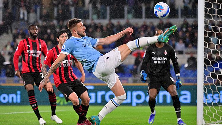 Pemain Lazio, Ciro Immobile sedang berusaha menjangkau bola dengan coba melobatnya.