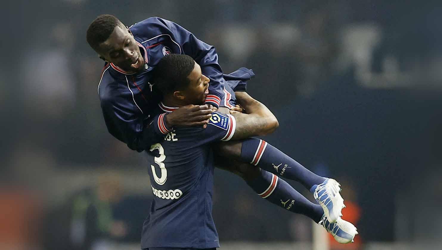 Selebrasi Pemain Presnel Kimpembe Paris St Germain merayakan dengan mengangkat Idrissa Gueye. Foto: REUTERS/Christian Hartmann - INDOSPORT