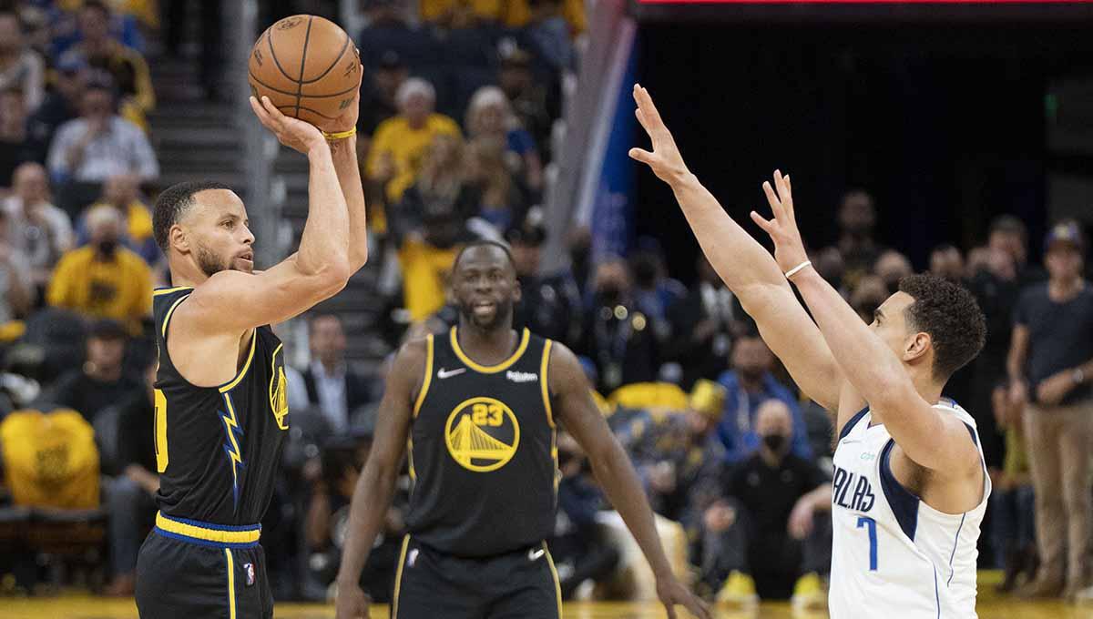 Pebasket Golden State Warriors Stephen Curry menembakkan bola basket ke arah center Dallas Mavericks Dwight Powell di laga NBA 2022. Foto: REUTERS/Kyle Terada - INDOSPORT