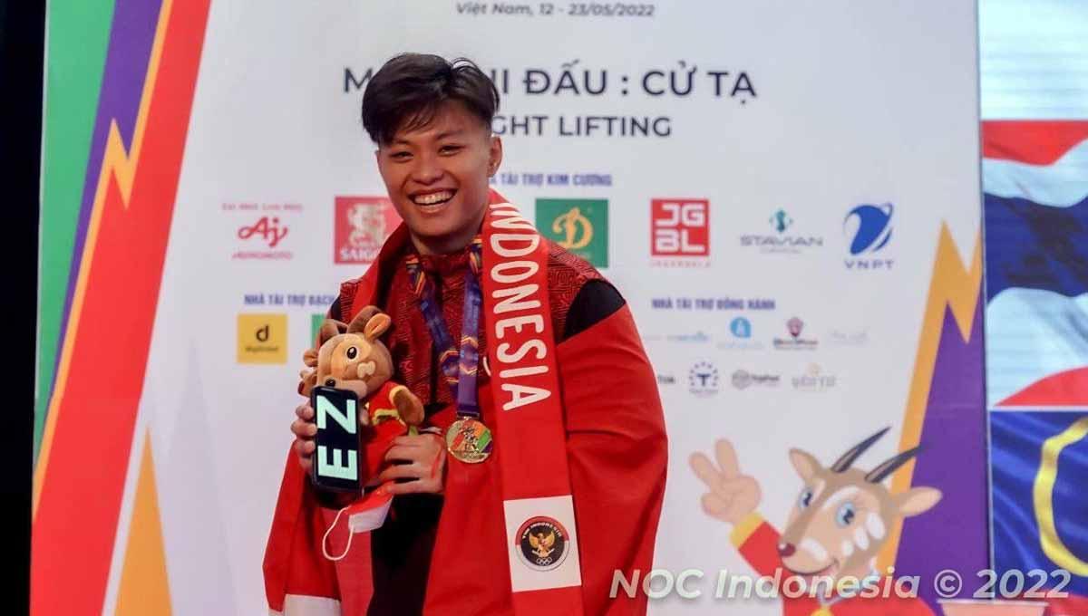 Rahmat Erwin Abdullah memamerkan medali emas yang didapatkannya di kelas 73kg putra di SEA Games 2021 Vietnam, Sabtu (21/05). Foto: NOC INDONESIA/MP MEDIA/EVAN ANDRAWS