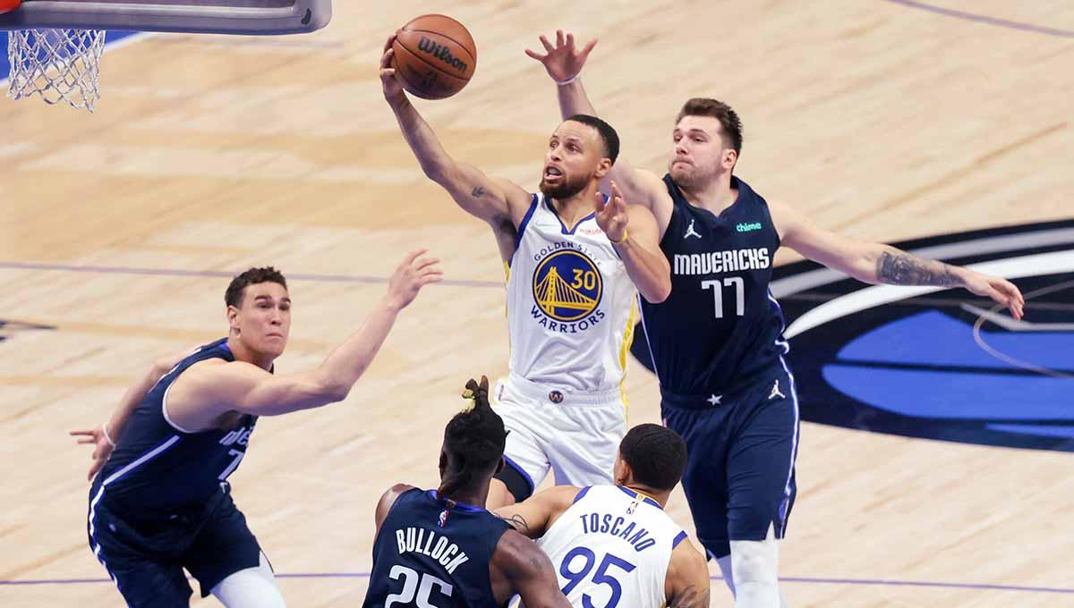 Pebasket Golden State Warriors Stephen Curry berusaha memasukan bola melewati pebasket Dallas Mavericks Luka Doncic di laga NBA 2022. Foto: REUTERS/Kevin Jairaj - INDOSPORT