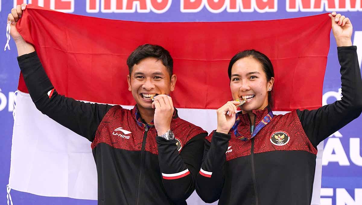 Petenis Indonesia, Christopher Rungkat/Aldila Sutjiadi, harus merayakan kemenangan dengan suasana gelap tanpa penerangan saat naik podium di SEA Games 2023. Foto: REUTERS/Athit Perawongmetha