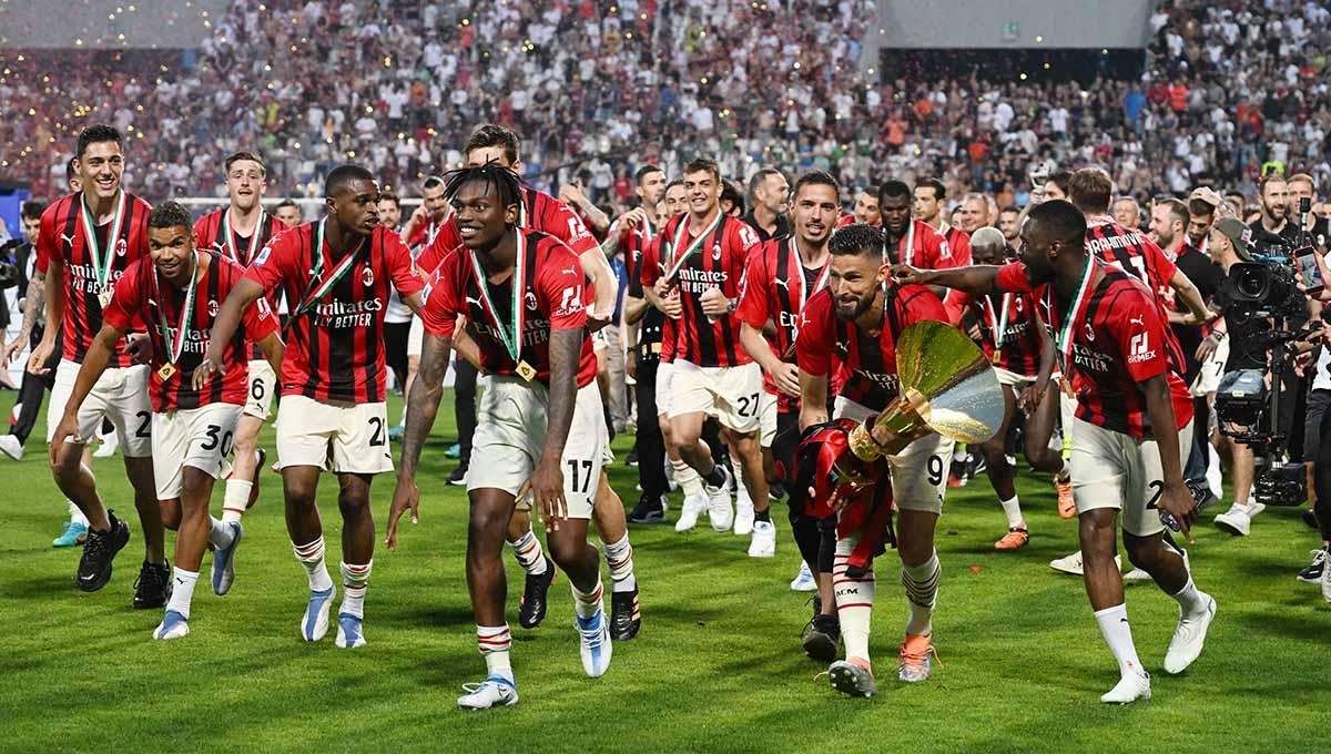 Indosport - Pemain AC Milan Olivier Giroud melakukan selebrasi dengan trofi dan rekan setimnya setelah menjuarai Liga Italia 2021/2022. Foto: REUTERS/Alberto Lingria