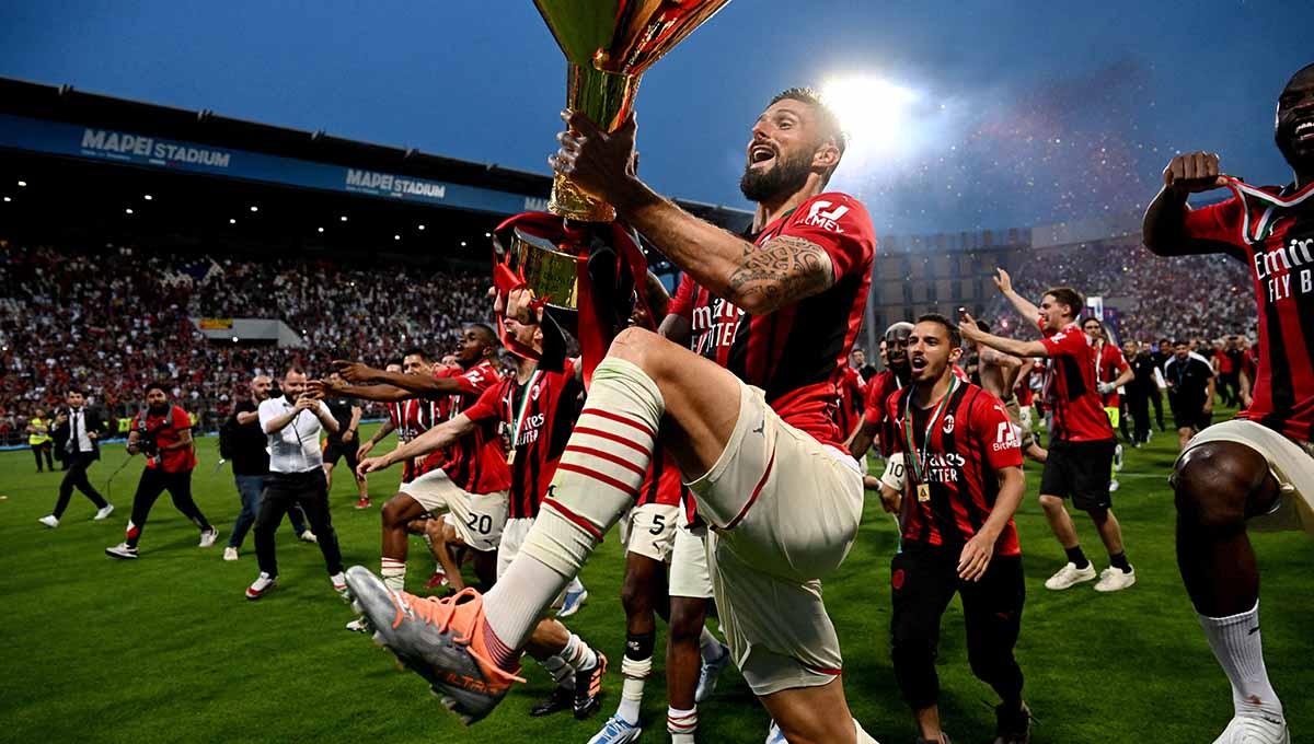 Indosport - Pemain AC Milan Olivier Giroud melakukan selebrasi dengan trofi juara Liga Italia 2021/2022. Foto: REUTERS/Alberto