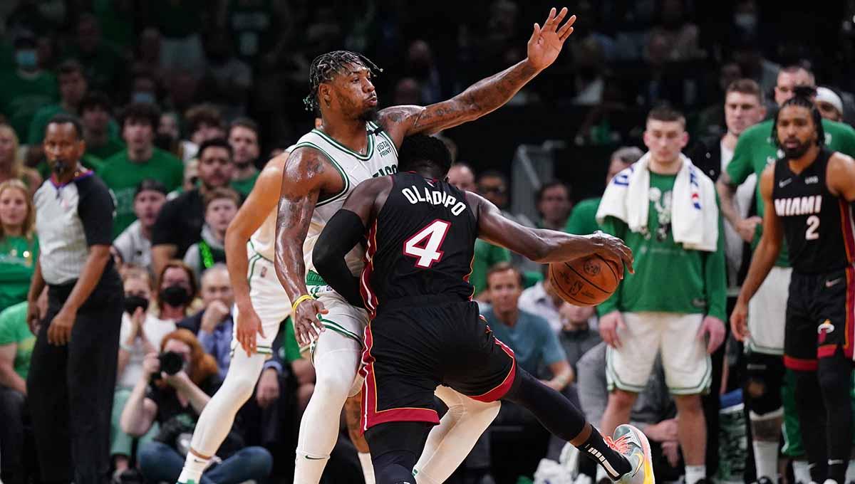 Pebasket Miami Heat Victor Oladipo coba menghindar dari hadangan pebasket Boston Celtics Marcus Smart pada laga NBA 2022. Foto: REUTERS/David Butler II