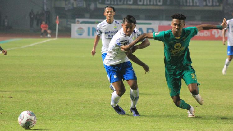 Pemain Persib, Febri Hariyadi berebut bola dengan pemain Persebaya.
