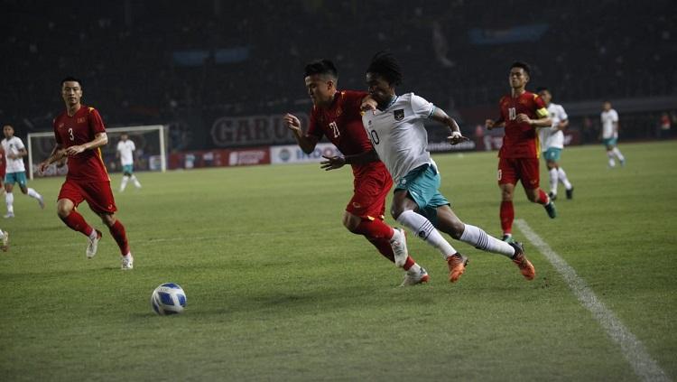 Indosport - Pemain Timnas Indonesia U-19, Marselino Ferdinan, tengah membawa bola dibayang-bayangi pemain Vietnam di Piala AFF U-19.