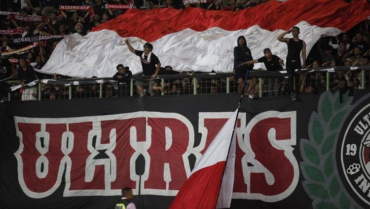 Suporter Timnas Indonesia membentangkan bendera merah putih di Stadion Patriot dalam laga kontra Vietnam di Piala AFF U-19.