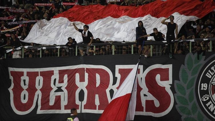 Suporter Timnas Indonesia membentangkan bendera merah putih di Stadion Patriot dalam laga kontra Vietnam di Piala AFF U-19. - INDOSPORT