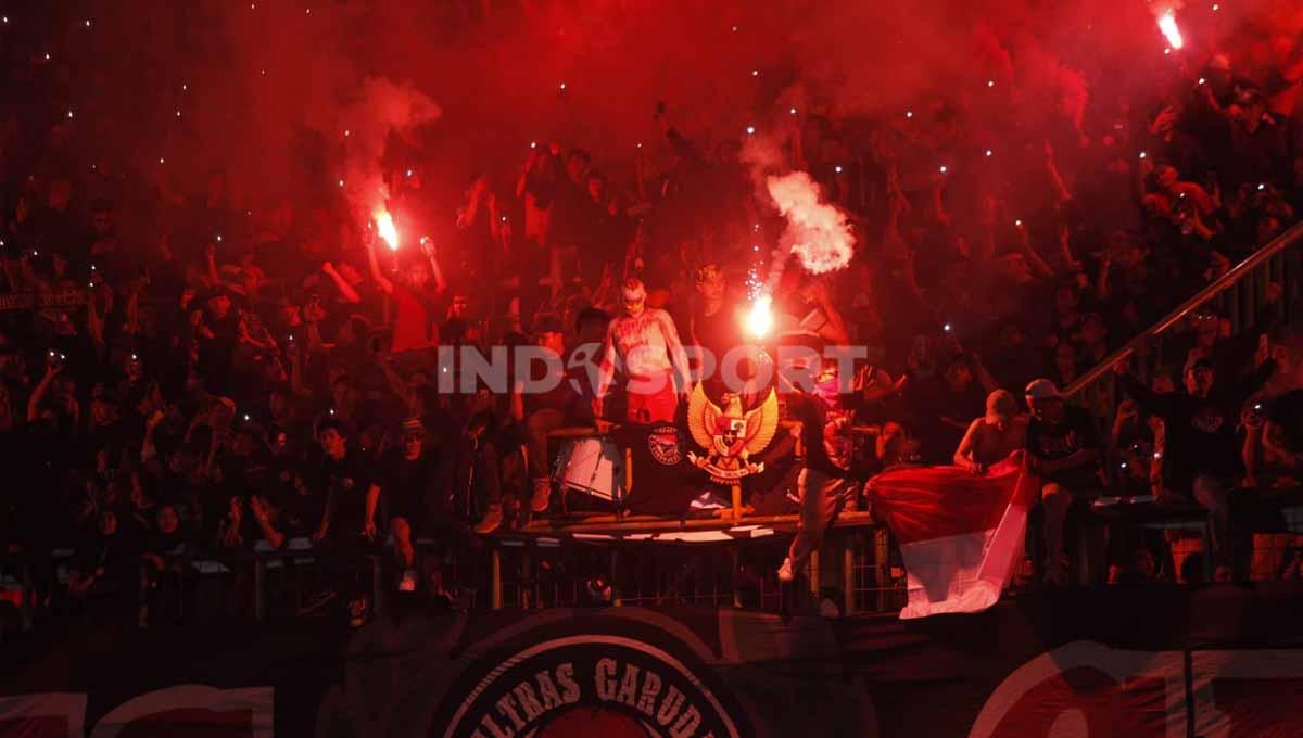 Suporter Ultras di tribun saat menyalakan flare pada pertandingan antara Indonesia U-19 vs Vietnam U-19 di Piala AFF U-19 2022.