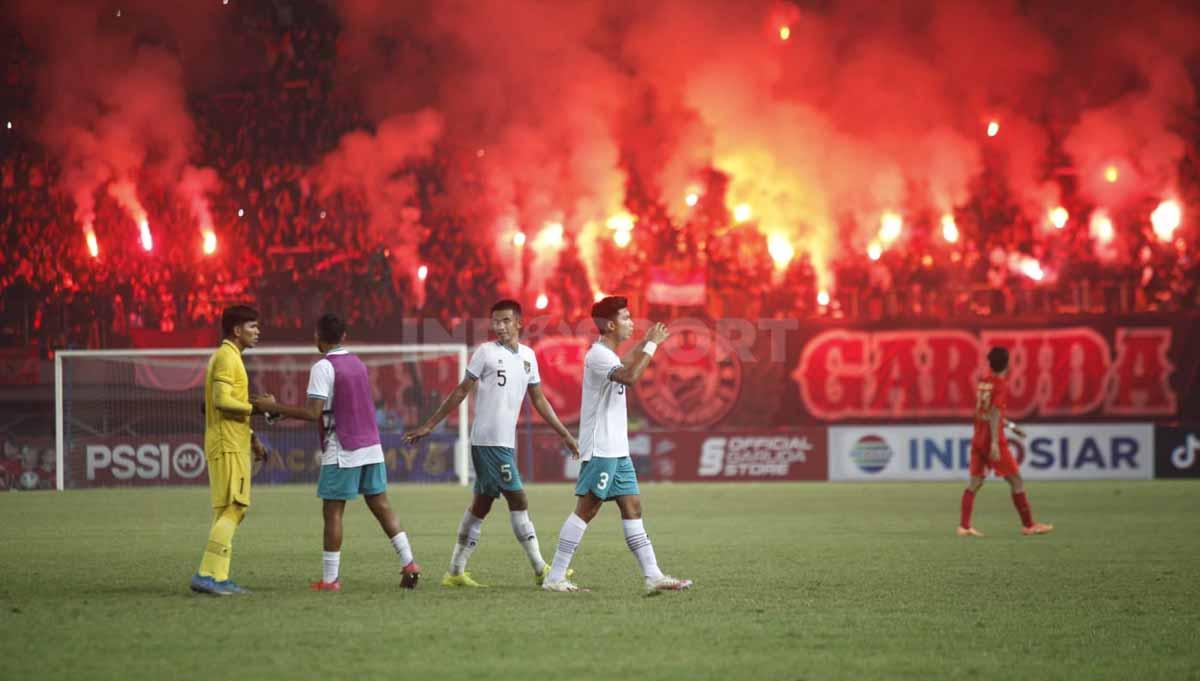 Suporter Ultras di tribun saat menyalakan flare pada pertandingan antara Timnas Indonesia U-19 vs Myanmar U-19 di Piala AFF U-19, Minggu (10/07/22). - INDOSPORT
