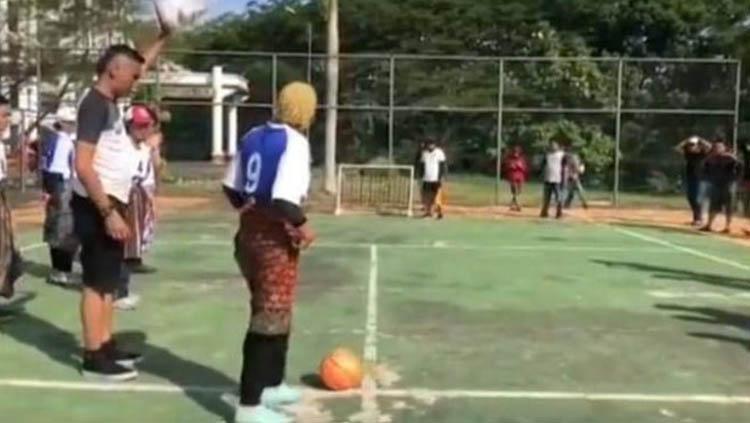 Seorang ibu yang diketahui pegawai Dishub Landak bersiap menendang bola ke gawang.