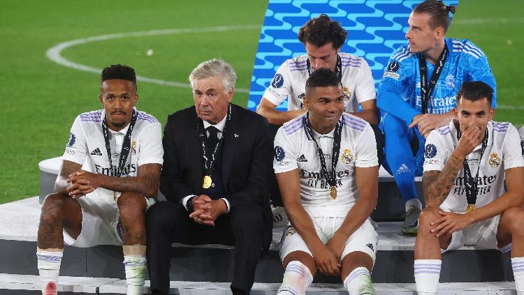 Indosport - Pemain Real Madrid Eder Militaol, pelatih Carlo Ancelotti dan Casemiro setelah memenangkan Piala Super Eropa 2022 REUTERS-Kai Pfaffenbach