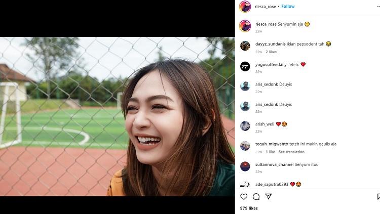 Riesca Rose mengenakan jersey sepak bola.