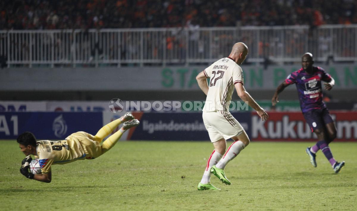 Kiper RANS Nusantara FC, Hilmasnyah (kiri) berhasil menggagalkan peluang striker Persija Jakarta, Michael Krmencik pada laga pekan kelima BRI Liga 1 2022/2023 di Stadion Pakansari, Sabtu (20/08/22).