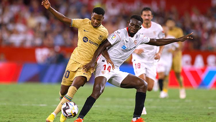 Duel antar pemain Barcelona dan Sevilla di Liga Spanyol.