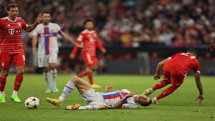 Bomber Barcelona, Robert Lewandowski dijatuhkan pemain Bayern Munchen, Lucas Hernandez di laga Liga Champions REUTERS/Lukas Barth