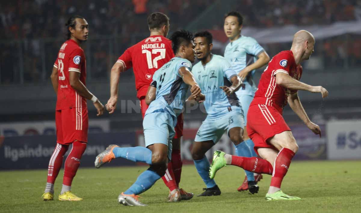 Kapten Madura United, Fachruddin Aryanto (tengah) mengikuti tiap gerakan striker Persija Jakarta, Michael Krmencik (kanan) pada pertandingan pekan ke-10 BRI Liga 1 2022/2023 di Stadion Patriot Candrabhaga, Bekasi, Sabtu (17/09/22).