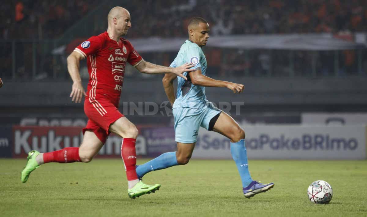 Bek Madura United, Cleberson de Souza (kanan) berhasil merebut bola dari striker Persija Jakarta, Michael Krmencik (kiri) pada pertandingan pekan ke-10 BRI Liga 1 2022/2023 di Stadion Patriot Candrabhaga, Bekasi, Sabtu (17/09/22).