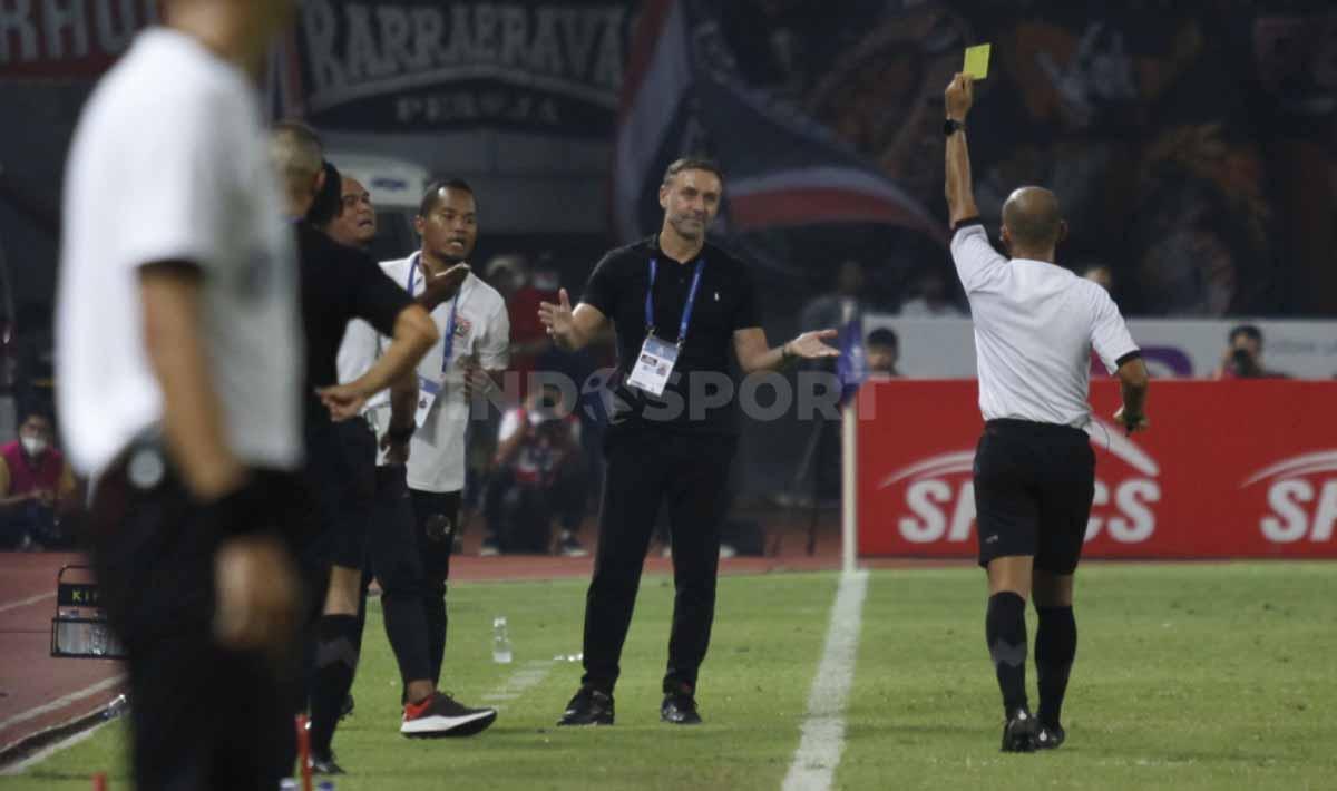 Wasit Ginanjar Rahman memeberikan kartu kuning kepada pelatih Persija Jakarta, Thomas Doll pada pertandingan pekan ke-10 BRI Liga 1 2022/2023 di Stadion Patriot Candrabhaga, Bekasi, Sabtu (17/09/22).