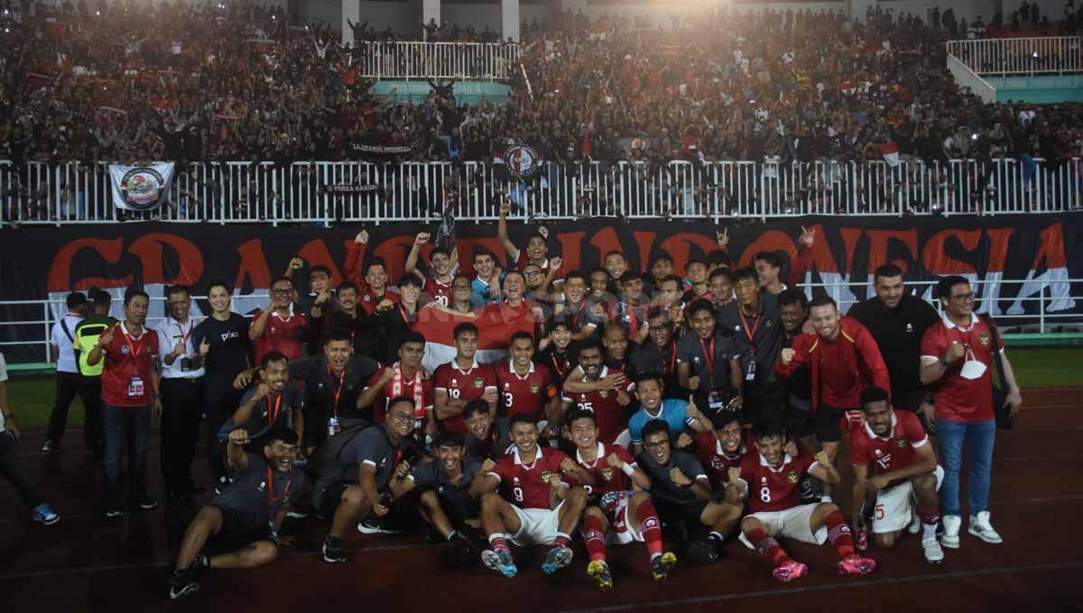 Indosport - Skuad Timnas Indonesia foto bersama berlatar belakang ribuan suporter usai laga melawan Curacao di Stadion Pakansari, Selasa (27/09/22) malam.